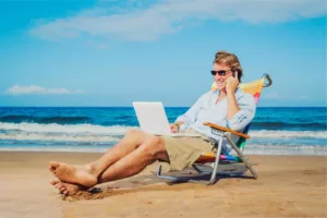Mann betreibt Affiliate Marketing mit Laptop am Strand